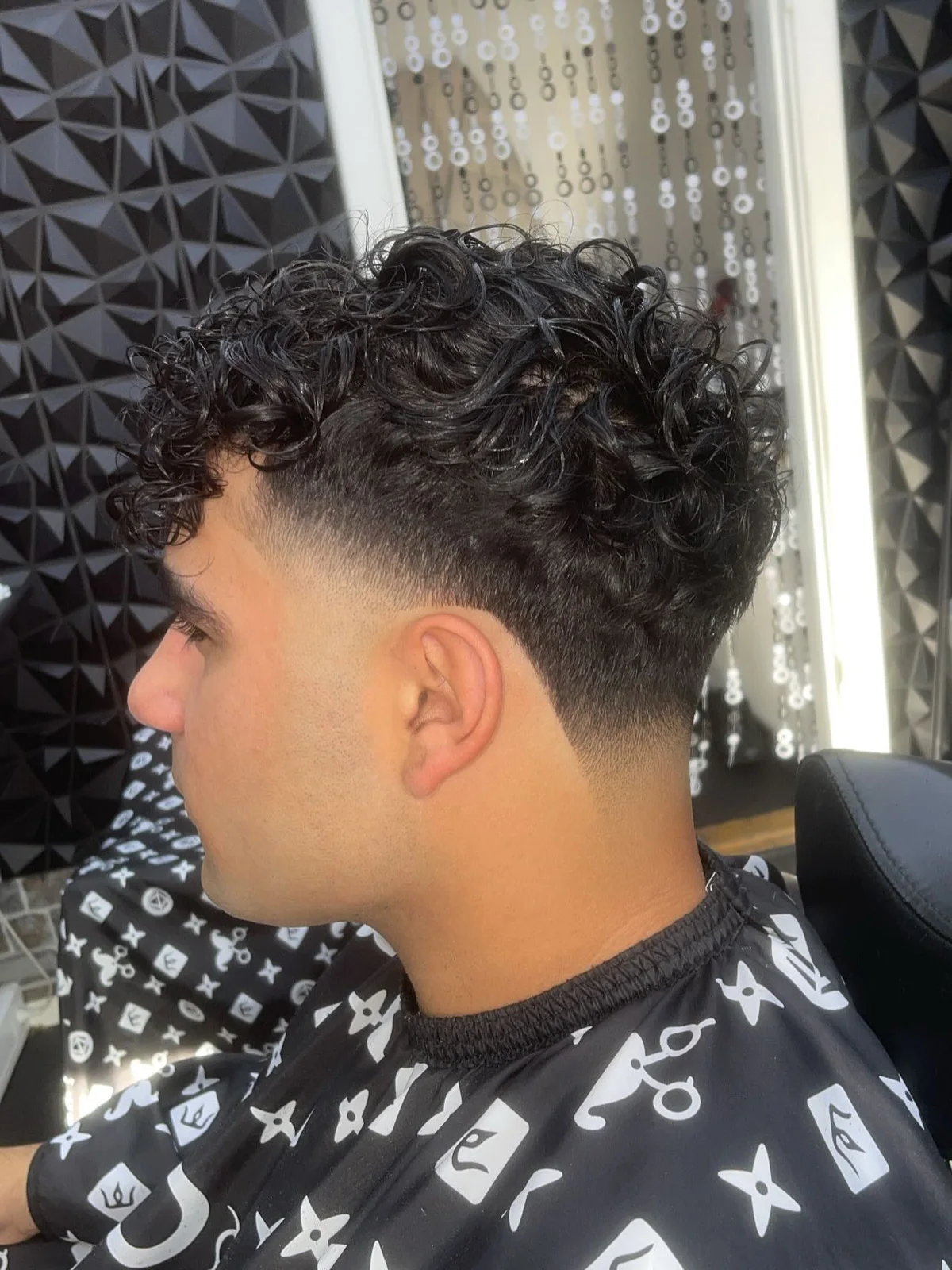 Krøllet herreklip med tæt fade hos Freshcuts